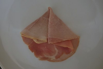 Traditional paper boat from a slice of ham — during folding process